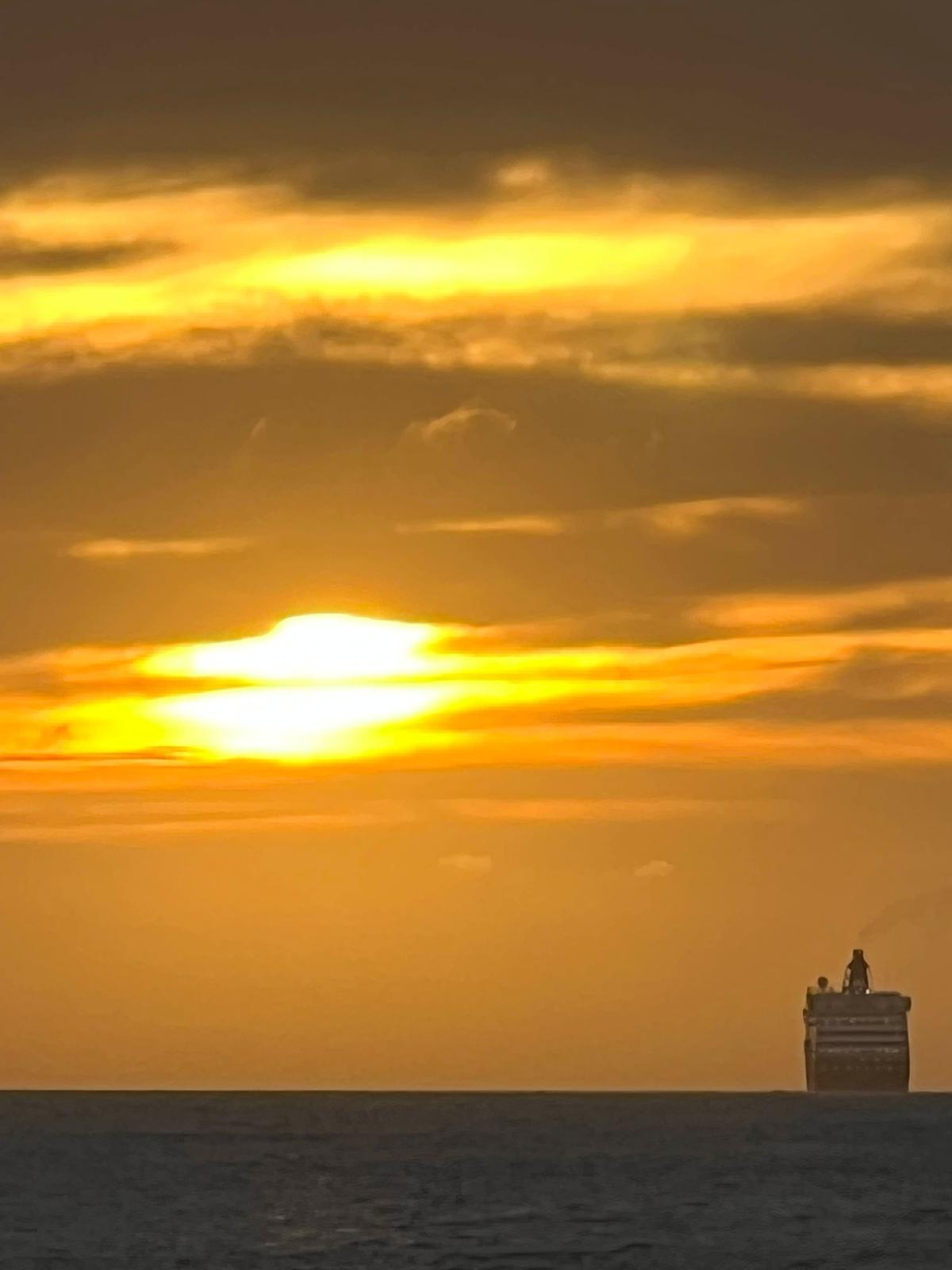 A luminous orange sunset over a dark sea